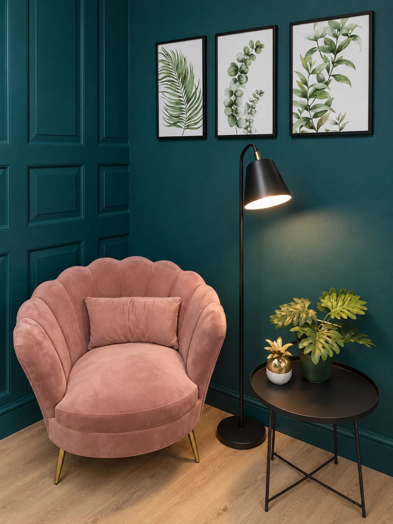 A reading corner with a rose-coloured chair and green wall panelling.