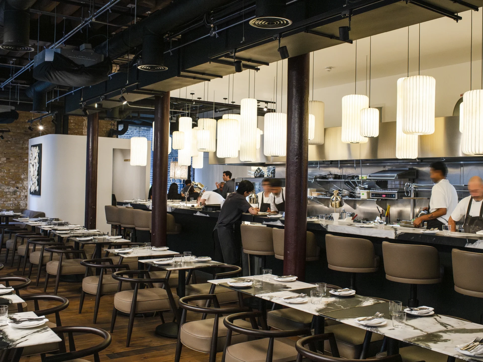 Pendant lights and a stone counter framing the open kitchen at Osteria Angelina